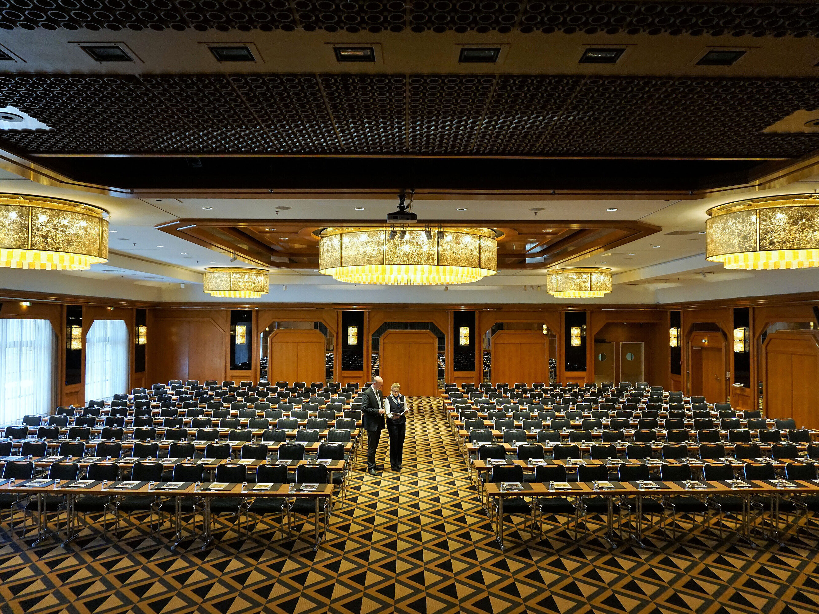 Salle de conférence élégante au Maritim Hotel Königswinter avec des sièges modernes et de magnifiques lustres.