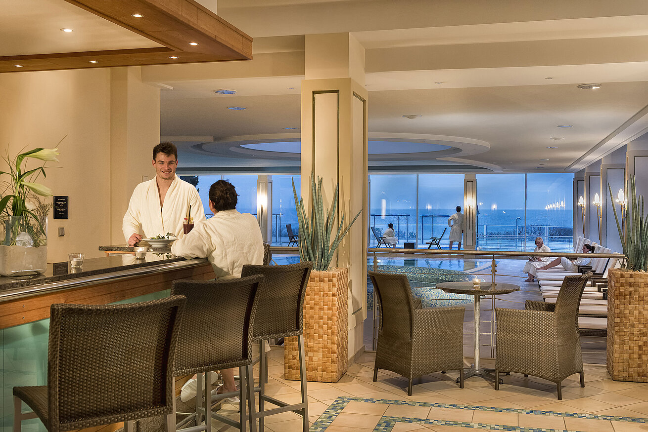 Area wellness con piscina e ospiti in accappatoi al Maritim Seehotel Timmendorfer Strand.