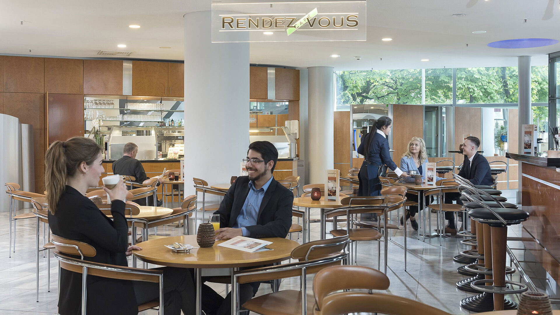 The Café Rendezvous at Maritim Hotel Frankfurt with guests enjoying coffee and friendly staff providing service.