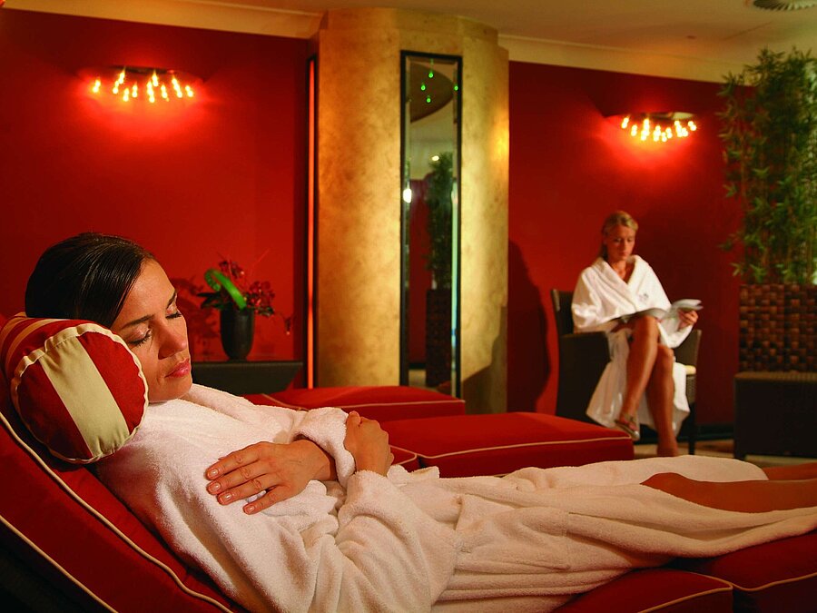 Lettini relax nell'area wellness del Maritim Seehotel Timmendorfer Strand, con due donne in accappatoi.