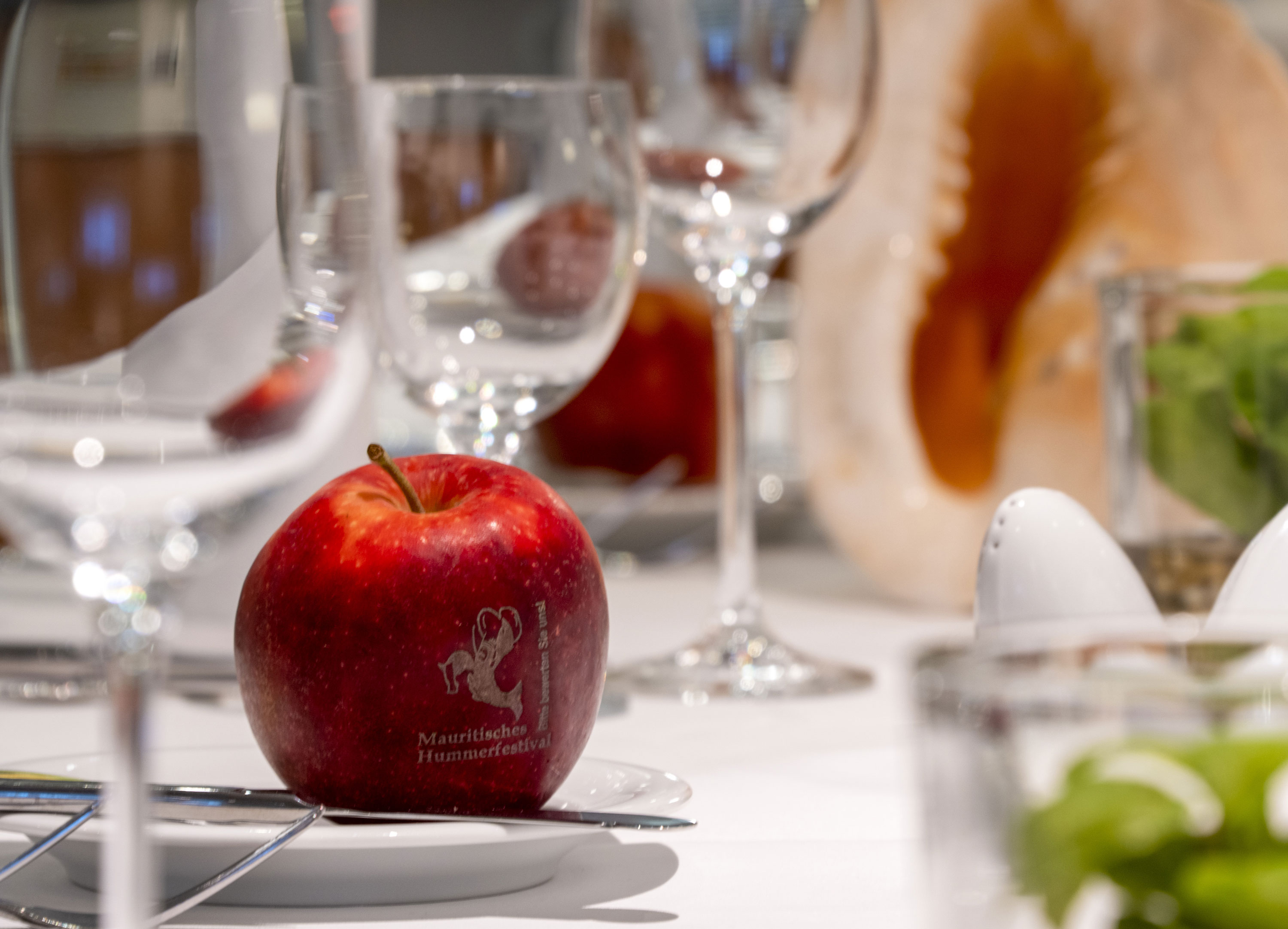 Decorative apple on a table at Maritim proArte Hotel Berlin, surrounded by glasses and decorative elements.