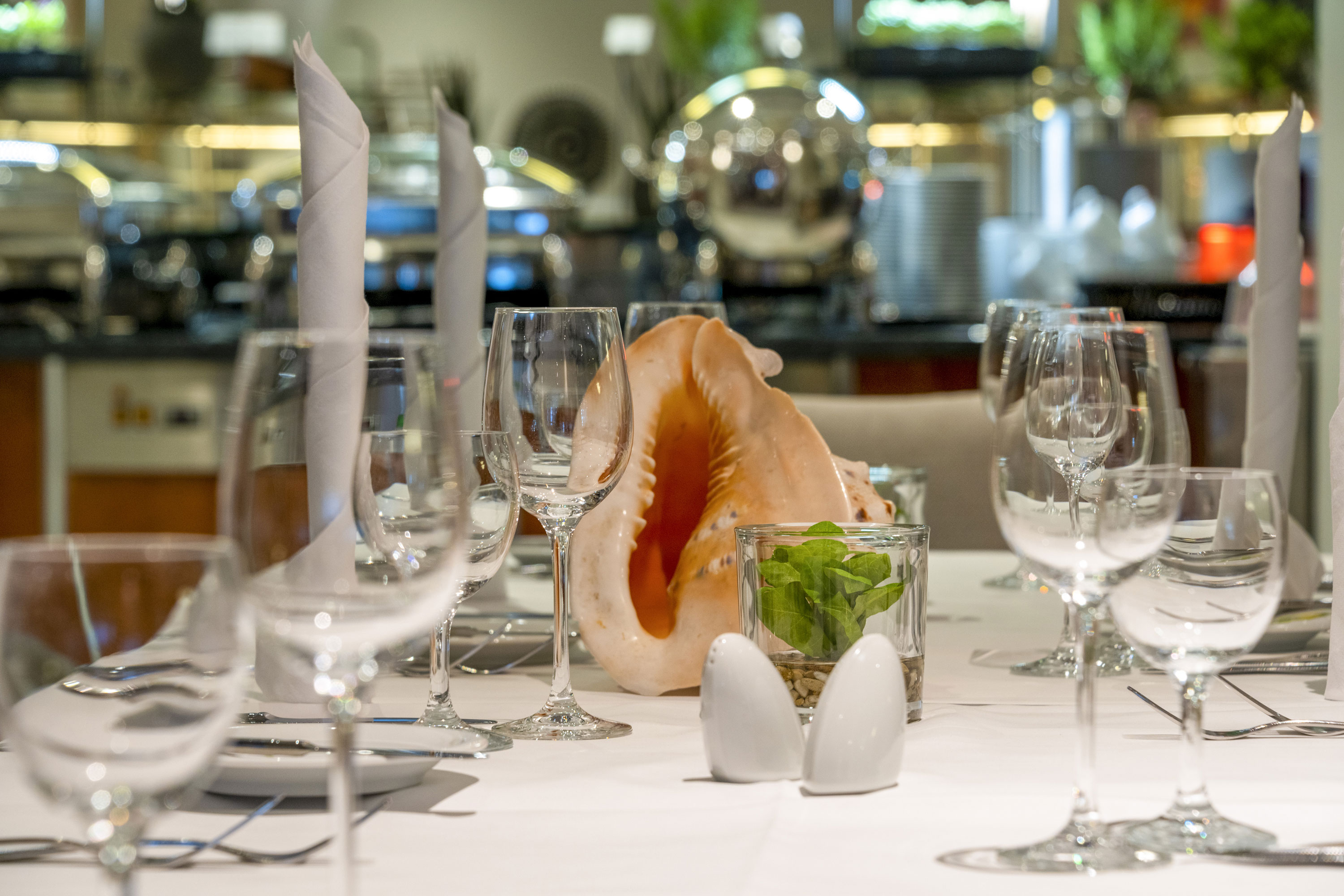 Elegantly set table at Maritim proArte Hotel Berlin with decorative shell and glass arrangement.