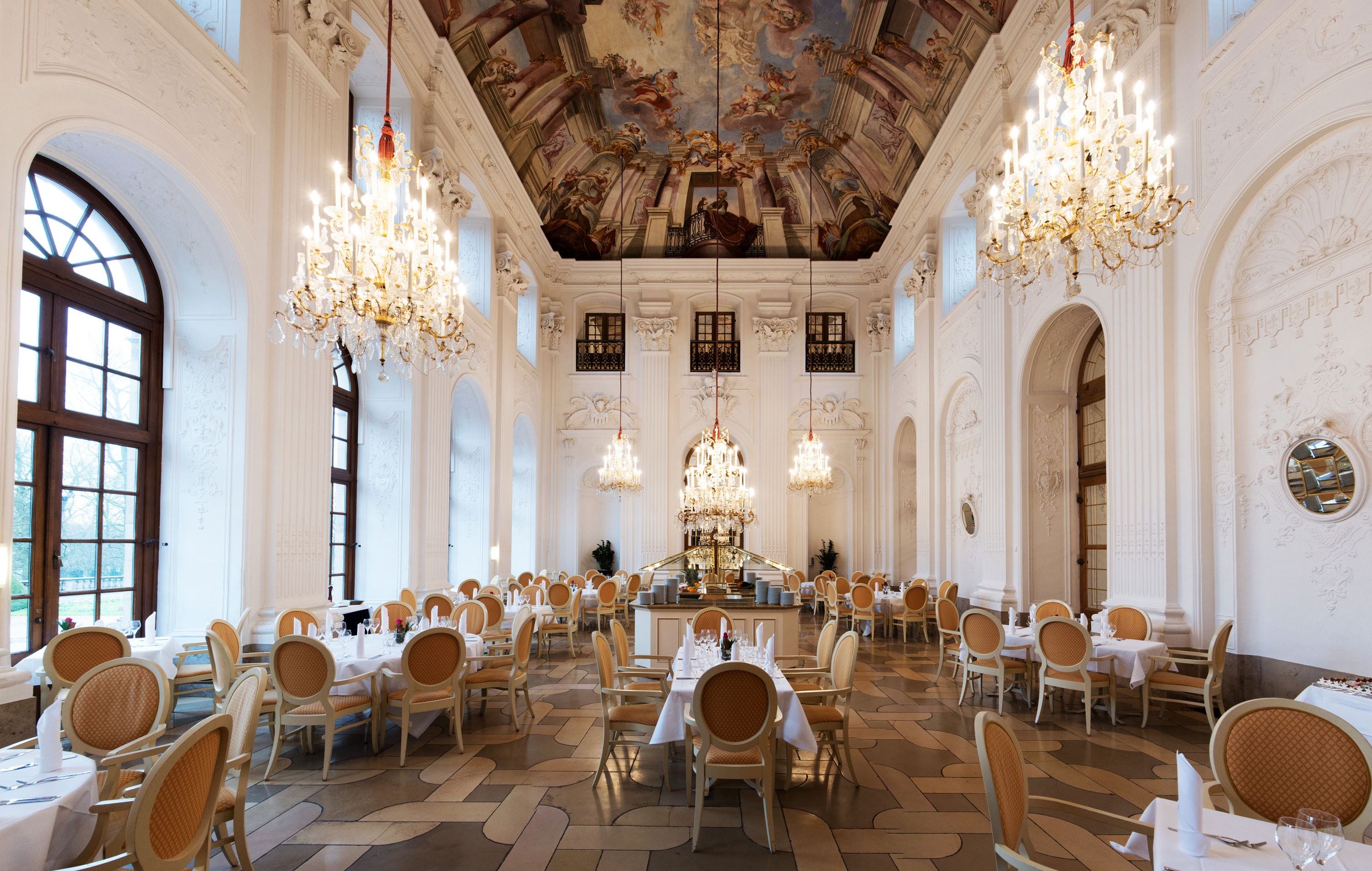 Élégante salle Apollo au Maritim Hotel Fulda avec lustres, plafond à fresques et tables raffinées.